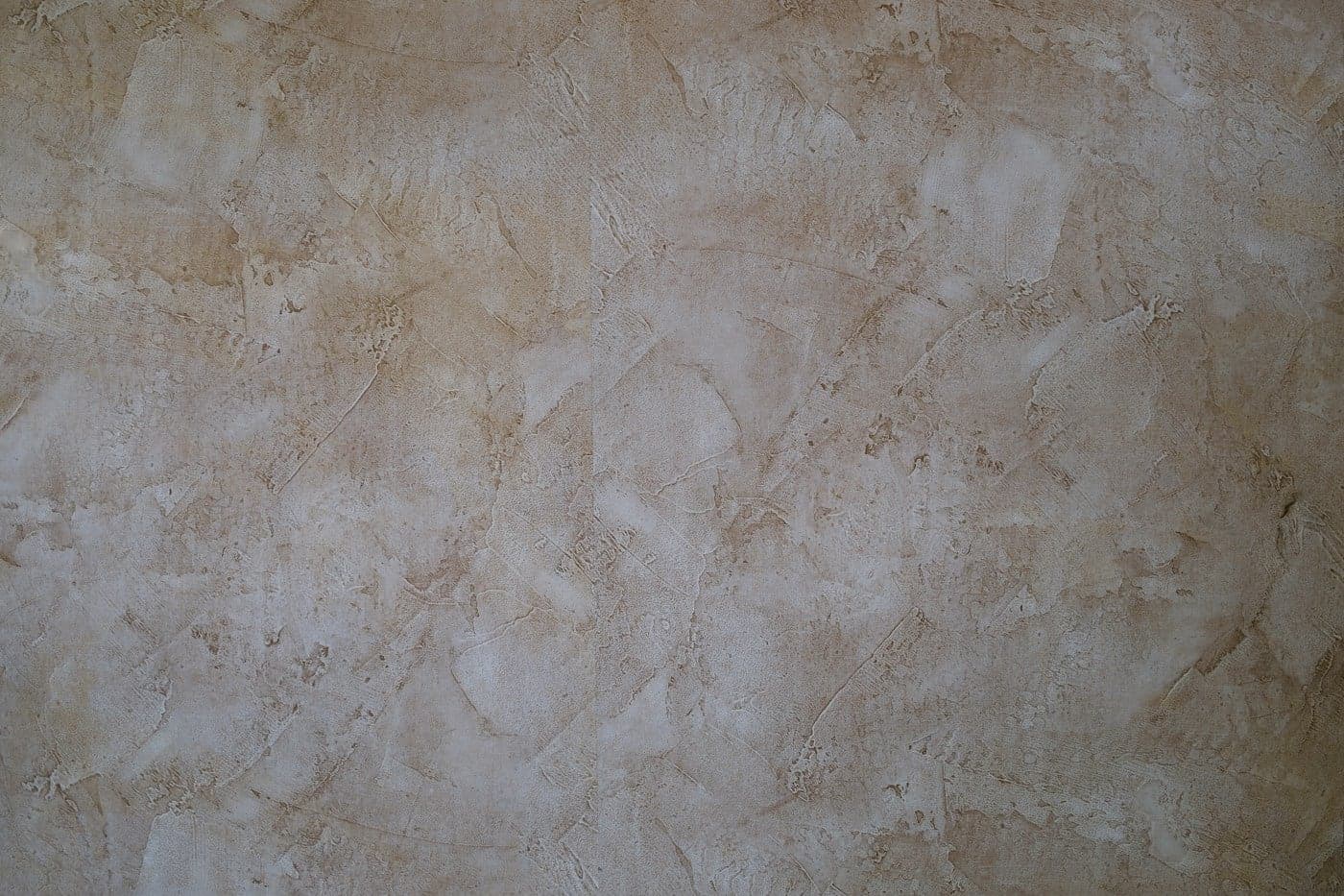 Close-up of layered, trowel-burnished Venetian plaster in warm stone tones