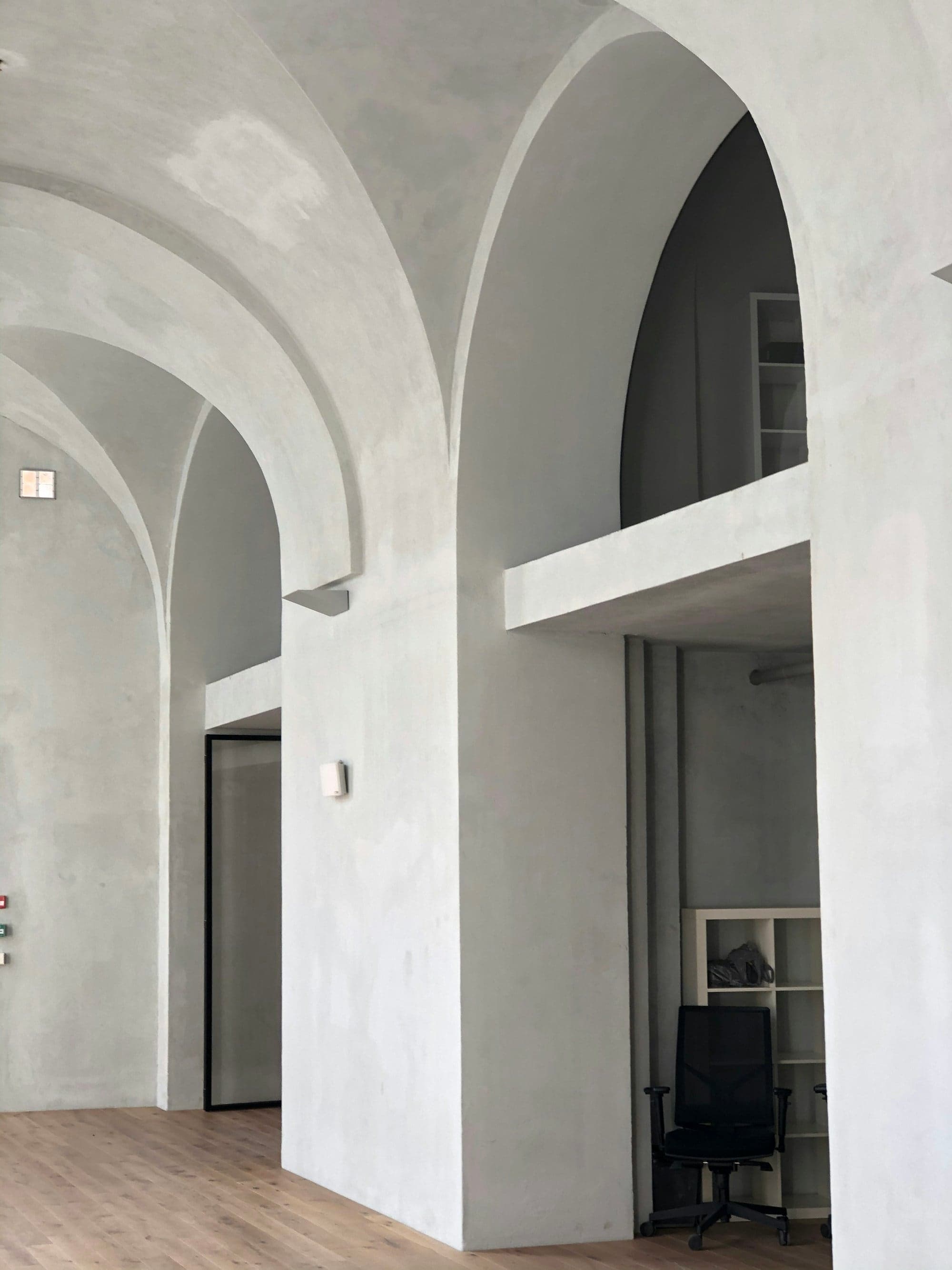Tall arched openings finished in smooth white plaster